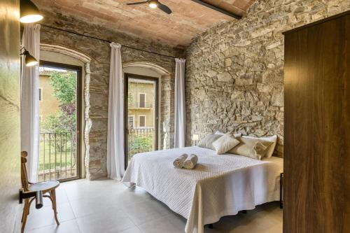 a bedroom with a bed with a stone wall at El Corral in Agullana