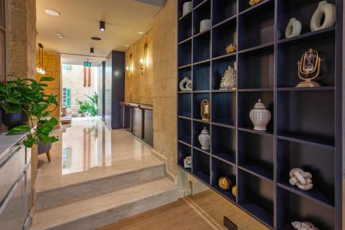 a hallway with a wall of shelves with vases at The Vincent Boutique Hotel, BW Premier Collection in Valletta