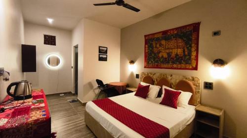 a hotel room with a bed and a painting on the wall at The Stone Hamlet Retreat in Barkot