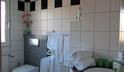a bathroom with a sink and a toilet and towels at Cologne Apartment – City, Trade Fair, E-Werk in Cologne
