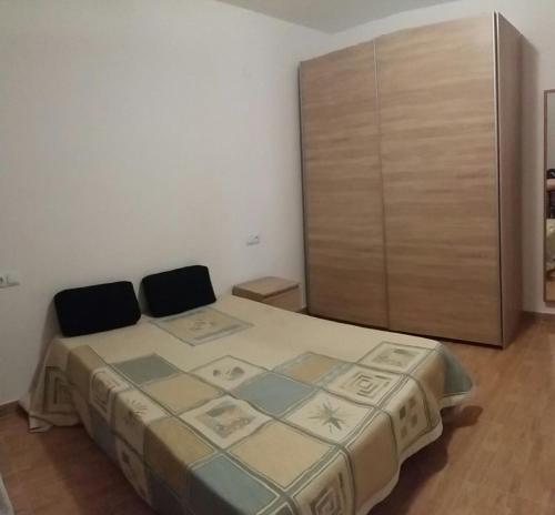 托雷維耶哈的住宿－Calle Santomera 17，一间卧室配有一张床和一个木制橱柜