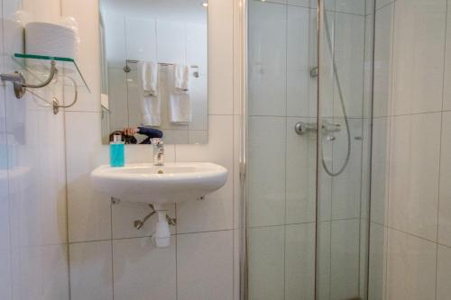 a bathroom with a sink and a shower at Grimstad Vertshus in Grimstad