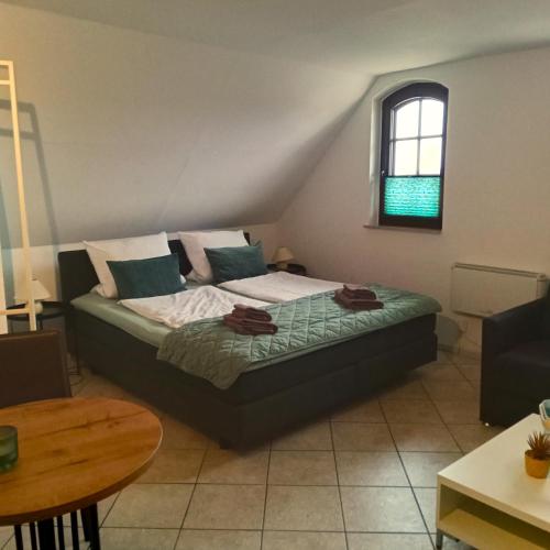 a bedroom with a bed and a table and a window at Fischstübchen Neeberg Apt 1 – Wald und Wiese in Krummin