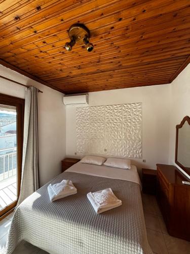 a bedroom with a bed and a wooden ceiling at Lena Apartments 4 in Potos