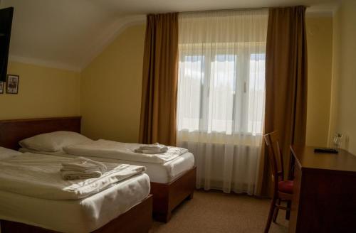 a hotel room with two beds and a window at Hotel Rudka in Kunštát