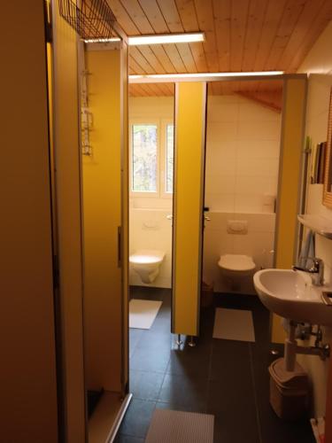 a bathroom with two toilets and a sink at Pension Waldegg Zermeiggern in Saas-Almagell