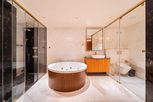 a bathroom with a tub and a sink and a toilet at Ratan International in Pondicherry