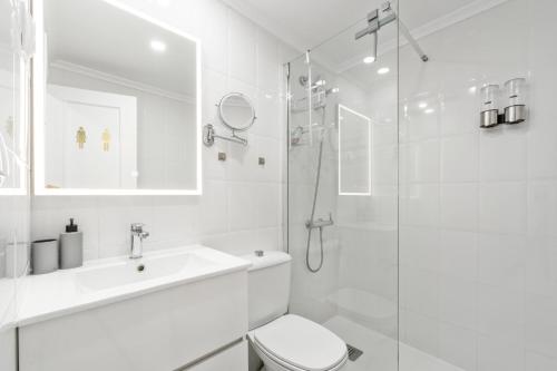 a white bathroom with a toilet and a shower at Mar y Sol in Torrevieja