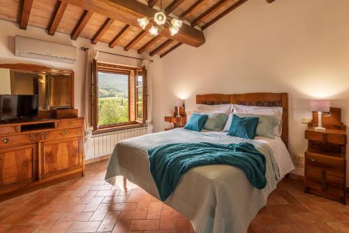 a bedroom with a bed with a television and a window at Casa Vecciano in Cetona