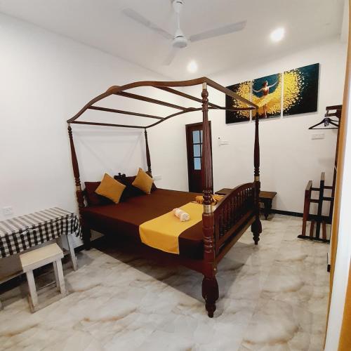 a bedroom with a wooden canopy bed in a room at Ashan Villa Ahungalla in Ahungalla