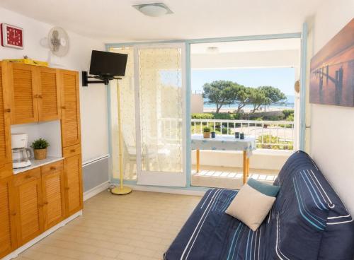 a living room with a couch and a sliding glass door at El Rivet - appartement vue mer avec parking in Sète