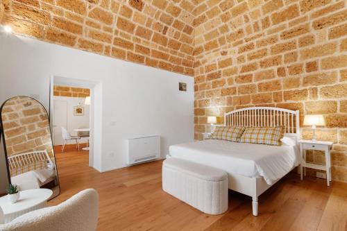 a bedroom with a bed and a brick wall at Terrazza del Pittore in Gioia del Colle