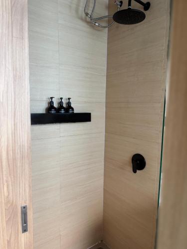 a shower stall with three bottles on a shelf at NOMAD Chic Private Pool Loft in Canggu, all inclusive stay in Dalung