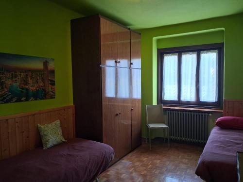 a green room with two beds and a window at Dai Barèta in Dare