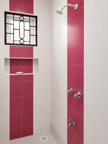 a shower with red and white tiles and a window at Prestige Leisure Hotel in Mtwapa