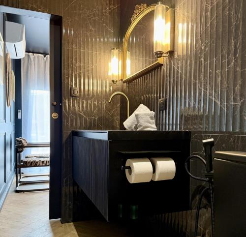 a bathroom with a sink and a toilet paper dispenser at Suite Vendôme - Elégance, Terrasse avec accès Piscine in Villeréal