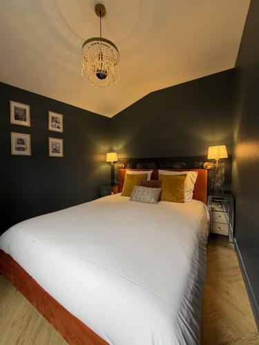 a bedroom with a large white bed with a black wall at Suite Vendôme - Elégance, Terrasse avec accès Piscine in Villeréal