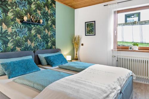 two beds in a room with a wall mural at Ruhige Einliegerwohnung mit Terasse in Altenkunstadt