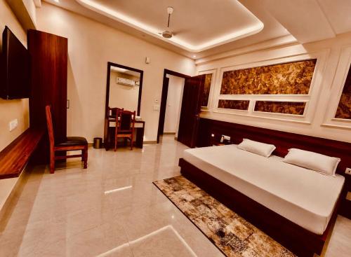 a bedroom with a bed and a window and a chair at Ram Anandam inn in Ayodhya