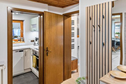 a kitchen with white cabinets and a wooden door at Ruhige Einliegerwohnung mit Terasse in Altenkunstadt