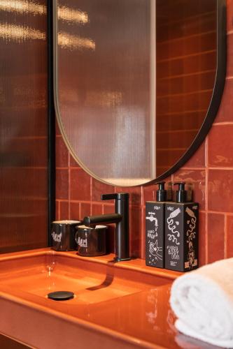 a bathroom counter with a sink and a mirror at Hotel Schani Naschmarkt - opening September 2026 in Vienna