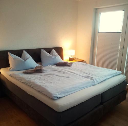 a large bed with two pairs of shoes on it at Fischstuebchen Neeberg in Krummin