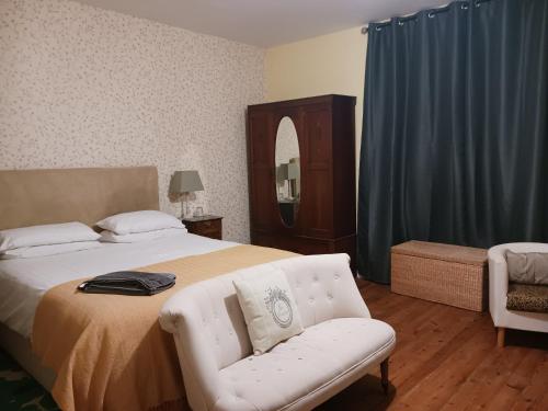 a bedroom with a bed and a chair and a mirror at Le Voltaire in Airvault