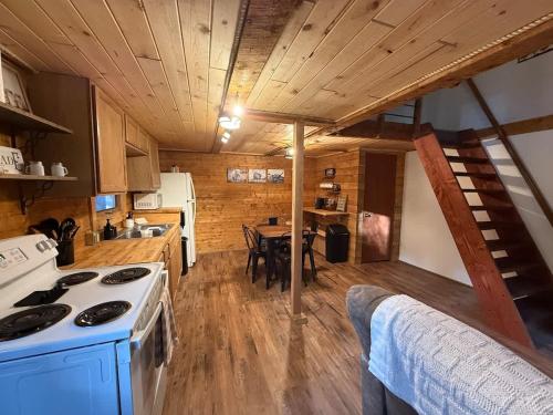 a kitchen with a stove and a dining room at Little Dry Cabin #3 in Fairbanks