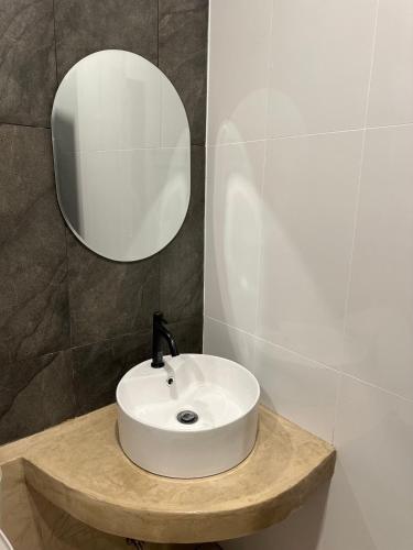 a bathroom with a white sink and a mirror at JanJao Resort in Nakhon Sawan