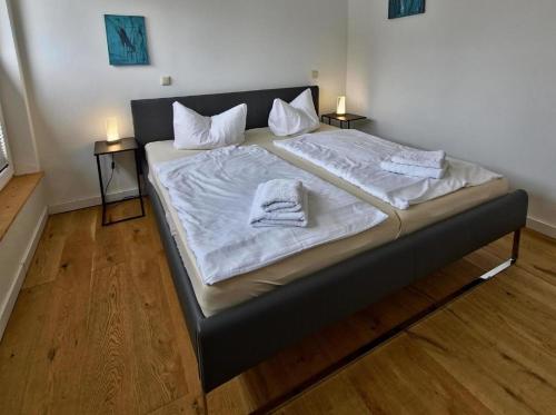 a large bed with white sheets and towels on it at Fischstübchen Neeberg Fewo 4 – Schwalbennest in Krummin