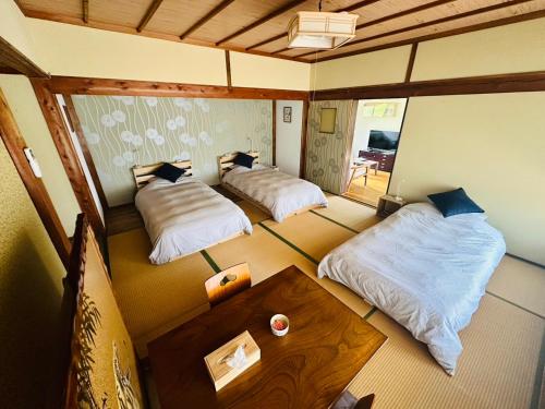 a room with two beds and a table in it at Cottage Kirihata in Tanabe