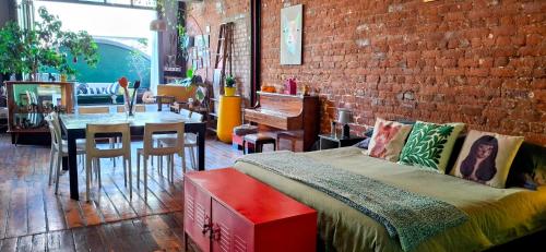 a bedroom with a bed and a brick wall at Cat-themed East City Loft Apartment in Cape Town