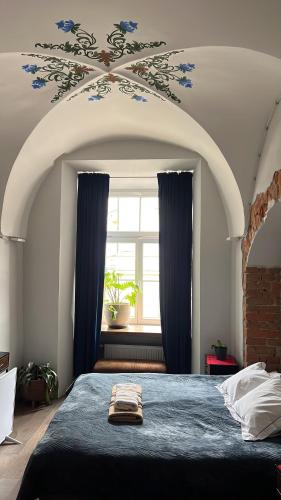 a bedroom with a bed and a window with blue curtains at Rynek 5 Winiarnia in Lublin