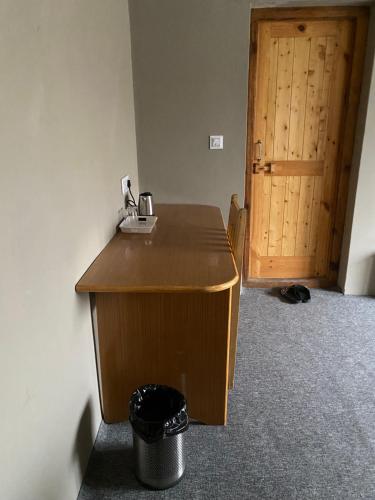 a wooden desk in a room with a wooden door at Tsogstot residency in Deskit