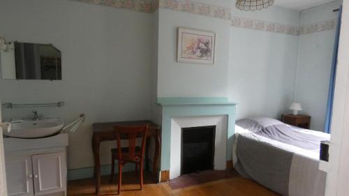 a bedroom with a bed and a sink and a table at Maison La Picade in Saint-Mamet