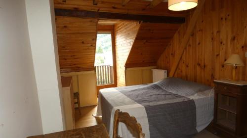 a bedroom with a bed in a wooden cabin at Maison La Picade in Saint-Mamet