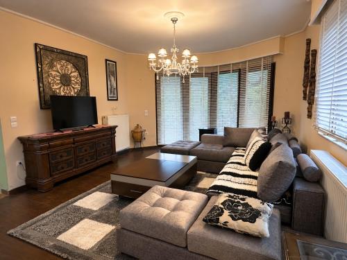 a living room with a couch and a television at Peaceful Retreat - Kefalos Stay with Patio views & gym in Kefalos