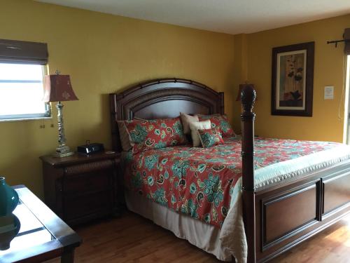 a bedroom with a bed with a red comforter at Crescent Arms Condominiums in Siesta Key