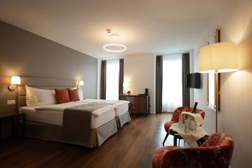 a hotel room with a bed and two chairs at Hotel Des Alpes in Lucerne