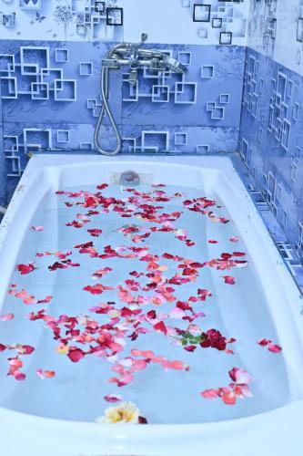 a bath tub filled with water with red flowers in it at Gitanjali Lodge in Rāmagiri Udayagiri