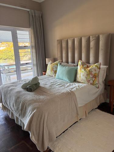 a bedroom with a large bed with a large window at Eight Umdoni North in Pennington
