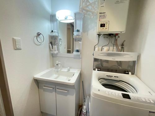 a small bathroom with a washing machine and a sink at エムズ千歳幸町2 in Chitose