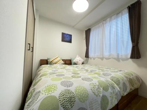 a bedroom with a bed and a window at エムズ千歳幸町2 in Chitose