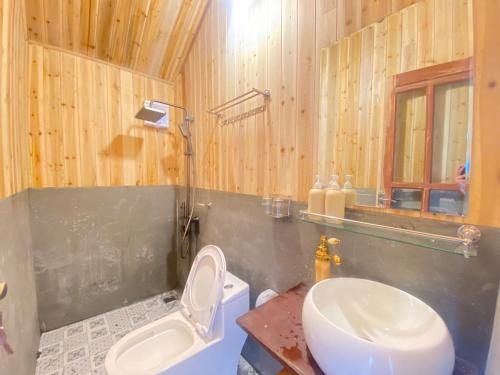 a bathroom with a toilet and a sink at A Phủ Home's Tà Xùa in Bắc Yên