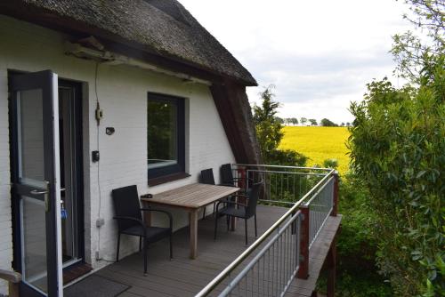 a porch with a wooden table and chairs on a house at FeWo Vobbe in Dänischenhagen
