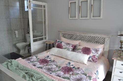 a bedroom with a bed with pink and purple pillows at Cozy Rustic Cottage in Windsor Park