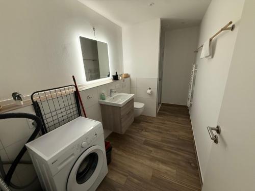 a bathroom with a washing machine and a sink at Ferienwohnungen in Borkheide in Borkheide
