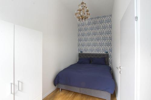 a bedroom with a bed in a room with a chandelier at Indigo am Gürtel in Vienna