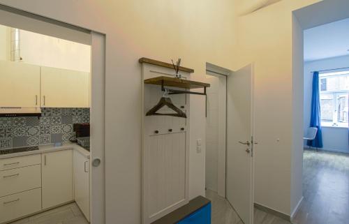 a kitchen with white cabinets and a pivot door at Indigo am Gürtel in Vienna