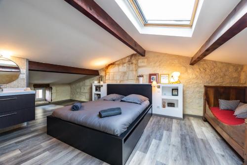 a bedroom with a large bed and a skylight at Le Loft - Château Le Noble in Saint-Germain-du-Puch